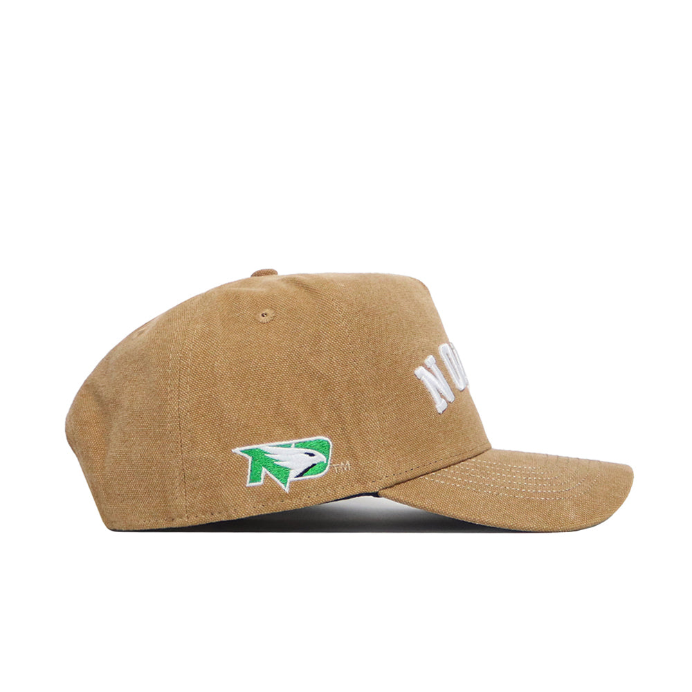 The North Dakota Rustic Hat by No Rivals is a tan structured fit cap with a curved brim, white embroidered front text, and a green, white, and black side logo. Shown from the side against a white background.