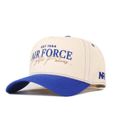 The Air Force Vintage Hat by No Rivals is a beige and blue snapback crafted from high-quality cotton for comfort. Featuring “Air Force EST 1954” and “Flying Always” text on the front, this structured cap has a blue brim and an NR logo on the side.