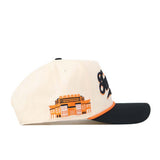 The No Rivals Tennessee Old Script Neyland Hat is a cream baseball cap featuring a black brim, orange trim, and an officially licensed embroidered Neyland building logo on the side.