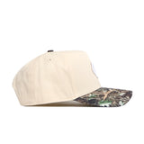The No Rivals UNC Camo Connector Hat features a structured fit in beige cotton with a camouflage brim, displayed from the side against a white background.