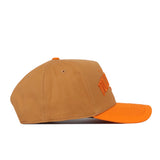 The Tennessee Rivalry Hat by No Rivals is a brown baseball cap crafted from high-quality cotton, featuring an orange brim and an embroidered orange logo on the front, shown from a side view.