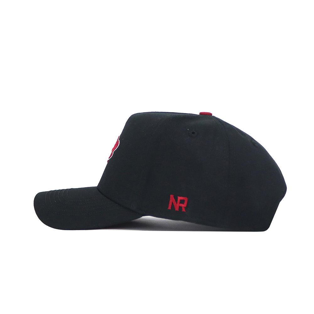 The Iowa State Patch Hat - Black by No Rivals is a high-quality cotton snapback featuring red NR embroidery near the back, a red top button, and a structured fit, shown here in a side view.