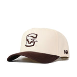 The No Rivals Creighton Espresso Hat is a beige snapback with a brown curved brim, large embroidered C and bird on the front, NR on the side, and made from premium cotton for comfort and style.