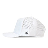 A side view of the Washington Huskies Golf Hat in white, by No Rivals. This cap features a perforated design with a flat brim, a small black and white NR embroidered logo patch on the lower side panel, and an adjustable snap back for your ideal gameday fit.
