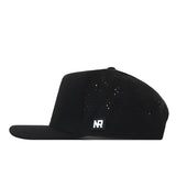 The No Rivals Purdue Golf Hat - Black is a flat-brimmed cap with small ventilation holes and an embroidered NR logo patch on the side. It features a snap back adjustment for a comfortable gameday fit and is shown in profile view against a white background.