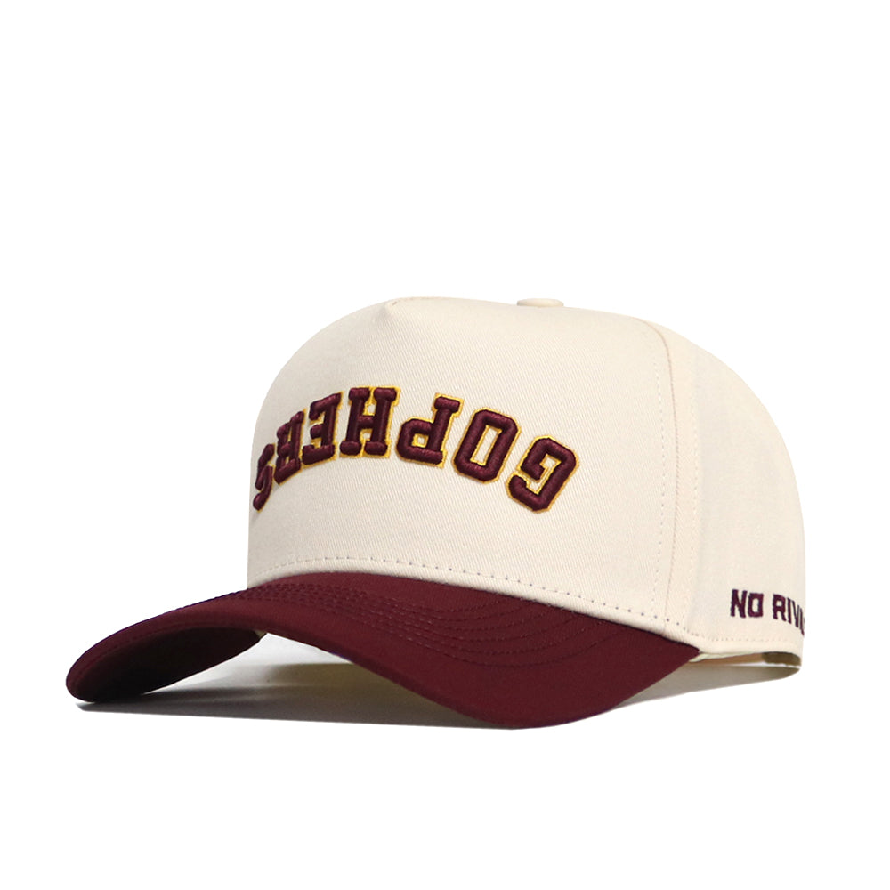 Show off your team spirit with the Minnesota Golden Gophers Upside Down Gophers Hat - Classic by No Rivals. This officially licensed cream baseball cap features a maroon brim and has “GOPHERS” embroidered upside down in maroon and gold letters on the front. The side of the brim displays “NO RIV” in maroon lettering.