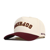 Show off your team spirit with the Minnesota Golden Gophers Upside Down Gophers Hat - Classic by No Rivals. This officially licensed cream baseball cap features a maroon brim and has “GOPHERS” embroidered upside down in maroon and gold letters on the front. The side of the brim displays “NO RIV” in maroon lettering.