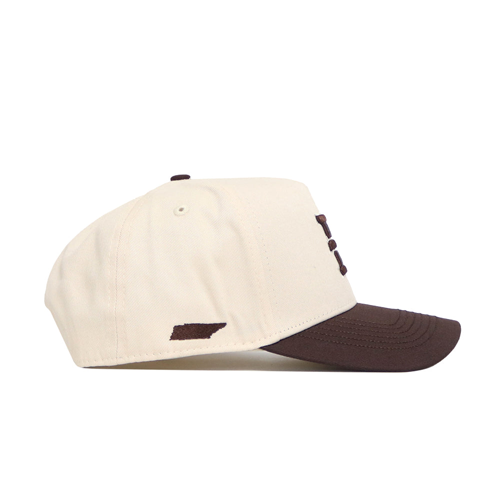 The No Rivals ETSU Espresso Hat is a beige snapback with a brown brim and a small brown state-shaped patch on the side, crafted from high quality cotton and shown from the left for a structured fit.