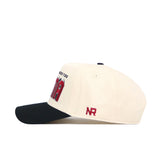 Side view of the No Rivals Alabama Alma Mater Hat, an officially licensed beige cap with a black brim, red "NR" embroidery on the side, front red and black details, a structured fit, snap back closure, and small black top button.