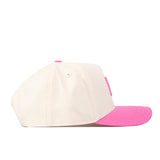 The Miami Pink Out Hat by No Rivals is a cream-colored snapback baseball cap featuring a pink brim and a matching pink top button, displayed from the side.