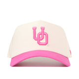 The Oregon Pink Out Hat by No Rivals is a stylish white baseball cap made from high-quality cotton, featuring a pink brim and pink embroidered “UO” on the front—making it the perfect snapback for showing your support as a breast cancer hat.