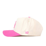 The No Rivals Oregon Pink Out Hat is a cream-colored snapback featuring a pink brim, a pink top button, and “NR” embroidered in pink on the side. It is officially licensed in support of the Breast Cancer Foundation.