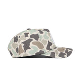 A side view of the No Rivals Montana Huntsman Hat, featuring a green, beige, and brown camouflage pattern in a classic 5-panel design, set against a white background.