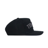 The No Rivals Tennessee Night Mode Hat is a black snapback with a flat brim and classic structured fit, made from high-quality cotton. It features raised, embroidered white text on the front panel and is shown from the side.