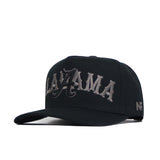 The Alabama Night Mode Hat by No Rivals is a black snapback with a flat brim, ALAYZAMA in large gray gothic embroidery on the front, and NR stitched on the side. Made from high-quality cotton with a structured fit.