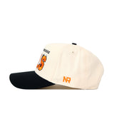 Side view of the No Rivals Tennessee Alma Mater Hat - Whiteout, a cream snapback with black brim, orange and black embroidered text, structured fit, and orange NR initials on the side. Made from premium cotton for comfort.