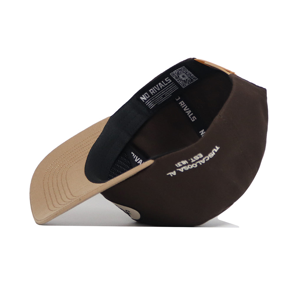 The Alabama Neutral Patch Hat by No Rivals is a brown and beige snapback with a black adjustable strap. Shown on its side, the high-quality cotton cap displays an interior NO RIVALS label and white printed text inside.