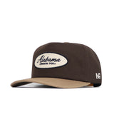 The Alabama Neutral Patch Hat by No Rivals is a structured brown and tan snapback, featuring an oval Alabama Crimson Tide patch on the front and NR branding on the side, crafted from high-quality cotton.