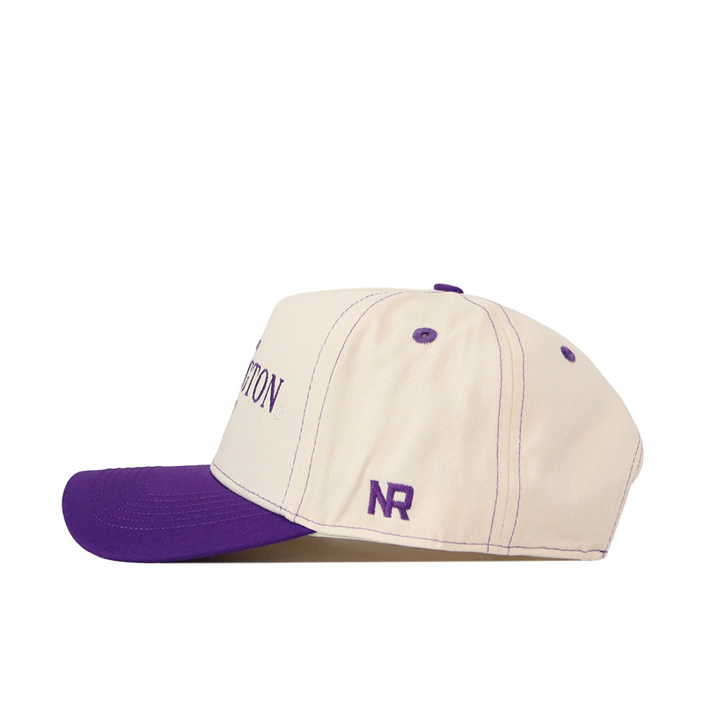 Introducing the Washington Huskies Vintage Hat by No Rivals—a beige and purple baseball cap crafted from premium quality cotton. This expertly made cap features a flat purple brim, with the embroidered “NR” initials in purple on the side, paired with matching stitching and eyelets. Designed for optimum comfort, it includes an adjustable snap back closure to ensure a perfect fit.