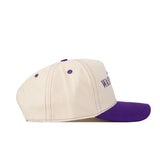 The No Rivals Washington Huskies Vintage Hat is crafted from high-quality cotton in beige, featuring a purple brim and matching purple accents such as stitching and ventilation holes. An embroidered purple logo with partial text appears on the side, while a snapback closure ensures a comfortable fit.