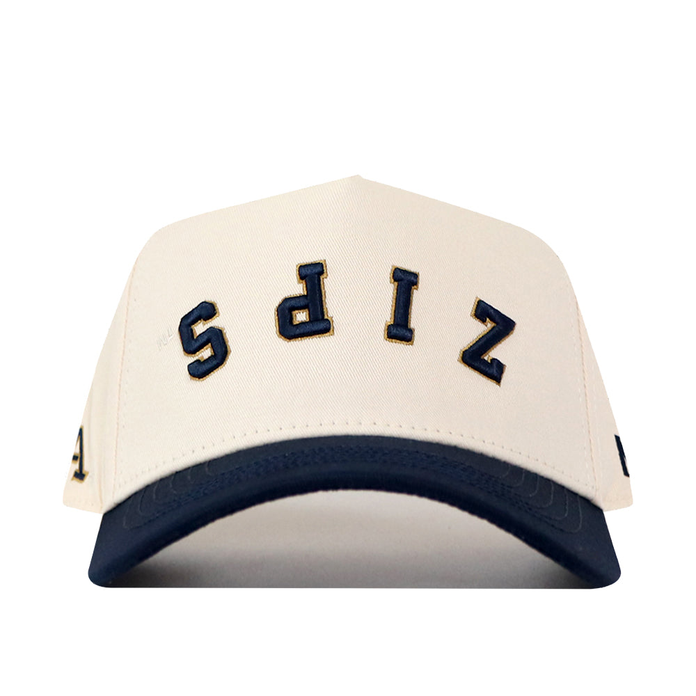 Introducing the Akron Zips | Upside Down Zips Hat - Classic by No Rivals: a white snapback baseball cap with a dark blue brim, showcasing “ZIPS” in large, navy-outlined letters sewn upside down on the front—a bold statement piece for any Akron Zips hat collector.