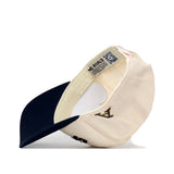 The Akron Zips | Upside Down Zips Hat - Classic by No Rivals is displayed inside-out, highlighting the inner label, detailed stitching, and the embroidered letters “A” and “ND” on the outside. The dark navy visor stands out as the hat is propped upright like an upside-down cap, offering a unique perspective on its meticulous craftsmanship.