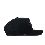 A side view of the Washington Huskies Outlaw Hat in black by No Rivals is displayed against a white background. The front panel showcases a partially visible, officially licensed white embroidered Washington Huskies logo, while the rest of the snap back cap remains plain.