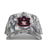 The No Rivals Auburn Outland Hat is a camouflage baseball cap showcasing a large, officially licensed embroidered Auburn University AU logo in navy blue and orange on the front, and features a snap back closure for an adjustable fit.