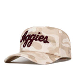 Introducing the Texas A&M Script Sand Camo Hat - Unstructured by No Rivals: This high quality cotton baseball cap features a beige and tan camouflage pattern with “Aggies” embroidered in dark red script on the front. Its unstructured, snap back design provides a comfortable and adjustable fit.