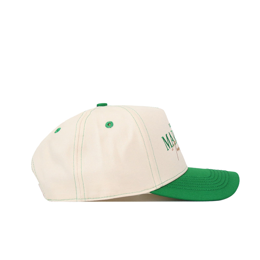 Introducing the Marshall Thundering Herd Vintage Hat by No Rivals—a cream-colored baseball cap with a green brim and matching green top button, expertly crafted from high-quality cotton. Displayed in a side profile against a white background, this hat features an embroidered logo for an added touch of style.