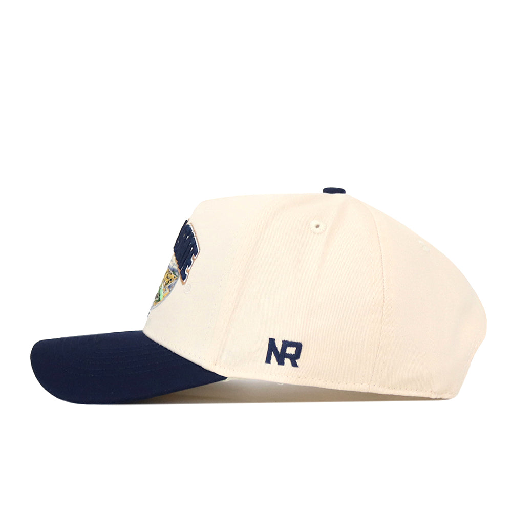 A white No Rivals Montana State Bobcats Stadium Hat with a navy blue brim, shown in a side view. The NR initials are embroidered in navy on the side, along with detailed embroidered logos for a polished finish.