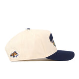 The No Rivals Montana State Bobcats Stadium Hat is a cream baseball cap with a navy blue brim, showcasing a wildcat logo on the side and a partially visible embroidered patch on the front—making it the ideal snapback to complete your gameday fit.