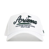 The No Rivals Arizona Clubhouse Hat is a white snapback with "Arizona" in large script and "The Grand Canyon State Golf Club" in block letters, featuring a small golf flag graphic. Made from a polyester-cotton blend with a structured fit.