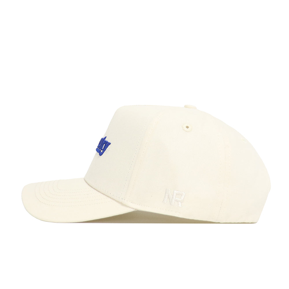 The No Rivals Kentucky Sideline Hat is a cream-colored cap with blue embroidery on the front and "NR" in white on the side. Shown in a side profile against a white background, it features a structured fit.