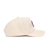 The No Rivals Mississippi State Stacked Hat is a beige structured-fit cap made from high-quality cotton, shown from the side with subtle dark red front embroidery, a curved brim, and visible stitching details.