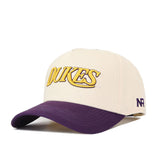 The JMU Vintage Wordmark Hat by No Rivals features a cream crown, "DUKES" embroidered in yellow and purple on the front, a purple curved brim, unstructured fit, snapback closure for comfort, and a small NR logo on the side.