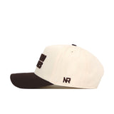 A cream-colored Colorado Buffaloes Espresso Hat by No Rivals is shown from the side, featuring a black bill and black embroidered "NR" lettering on the side. The cap includes an adjustable snapback closure for a comfortable fit.