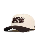 Introducing the Colorado Buffaloes Espresso Hat by No Rivals—a beige and brown baseball cap featuring an officially licensed Colorado Buffaloes embroidered logo in large brown letters on the front, with "NF" stitched on the side. This cap is designed with a curved brim, structured crown, and a convenient snapback closure for an adjustable fit.