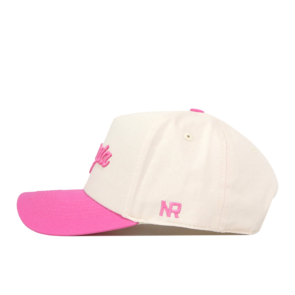 Introducing the Georgia Pink Out Hat by No Rivals — a cream-colored baseball cap featuring a vibrant pink brim. The front showcases bold, pink embroidered text, while the signature NR letters are stitched on the side. This stylish snapback hat is perfect for making a meaningful statement and showing your support as a breast cancer hat or for raising awareness about causes like the National Breast Cancer Foundation.