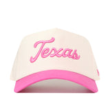 The No Rivals Texas Pink Out Hat is an officially licensed snap back featuring a white crown, a pink brim, and “Texas” embroidered in pink cursive on the front—making it a stylish and spirited breast cancer supporter hat.