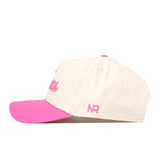 The No Rivals Texas Pink Out Hat is a white snapback baseball cap featuring a vibrant pink brim and pink embroidered “NR” lettering on the side. Officially licensed as a breast cancer awareness hat, it is displayed in profile against a white background.