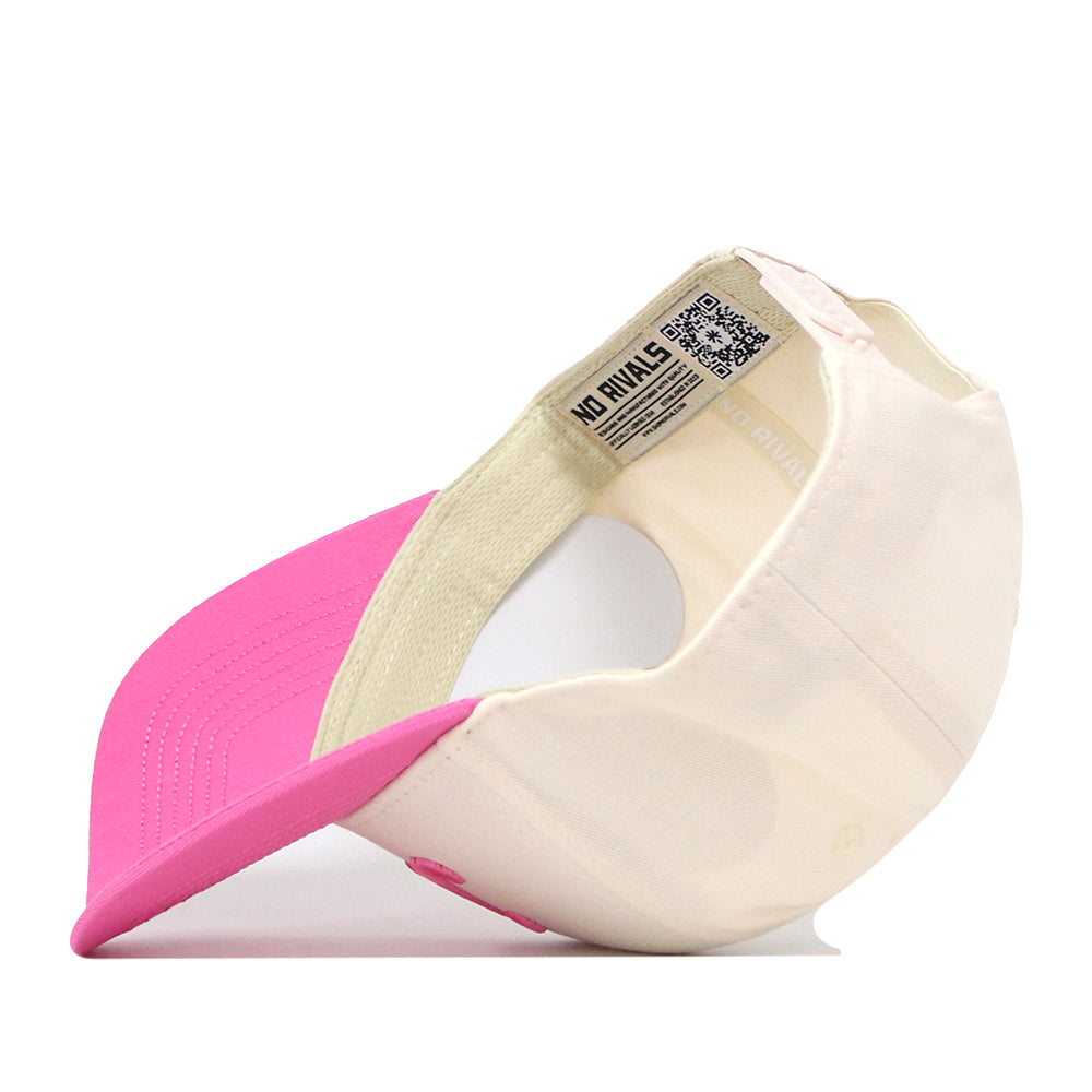 The No Rivals Texas Pink Out Hat is pictured upside down, showcasing its interior details such as the label and stitching. This officially licensed cap features a curved pink brim, a cream crown, and an adjustable snap back closure for a comfortable fit.