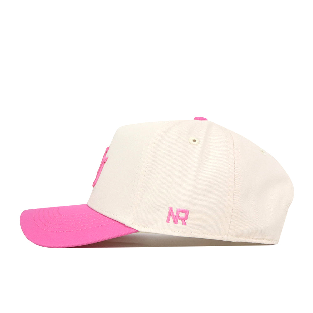 A cream-colored Utah Pink Out Hat by No Rivals, featuring a pink brim and pink embroidered NR letters on the side, viewed from the left—an officially licensed breast cancer snapback cap.