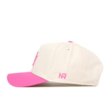 A cream-colored Utah Pink Out Hat by No Rivals, featuring a pink brim and pink embroidered NR letters on the side, viewed from the left—an officially licensed breast cancer snapback cap.