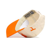The Tennessee Stadium Hat by No Rivals is a cream and orange snapback, shown upside down to reveal the inside. Made of high quality cotton, it features an orange letter T on the side and a NO RIVALS tag on the inner band.