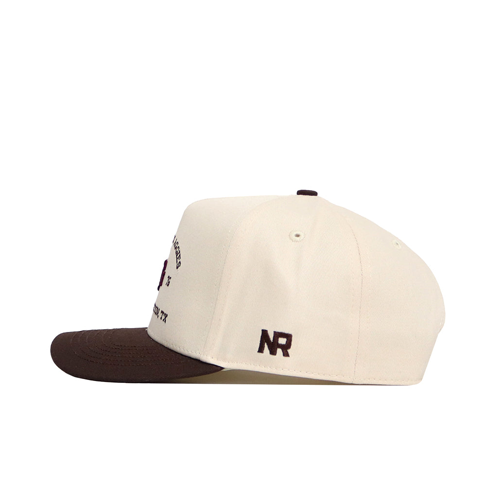 The No Rivals Texas A&M Outlaw Hat - Classic features a cream cotton construction with a brown brim, NR initials embroidered in brown on the left side, and a stylish snapback design seen from the side.