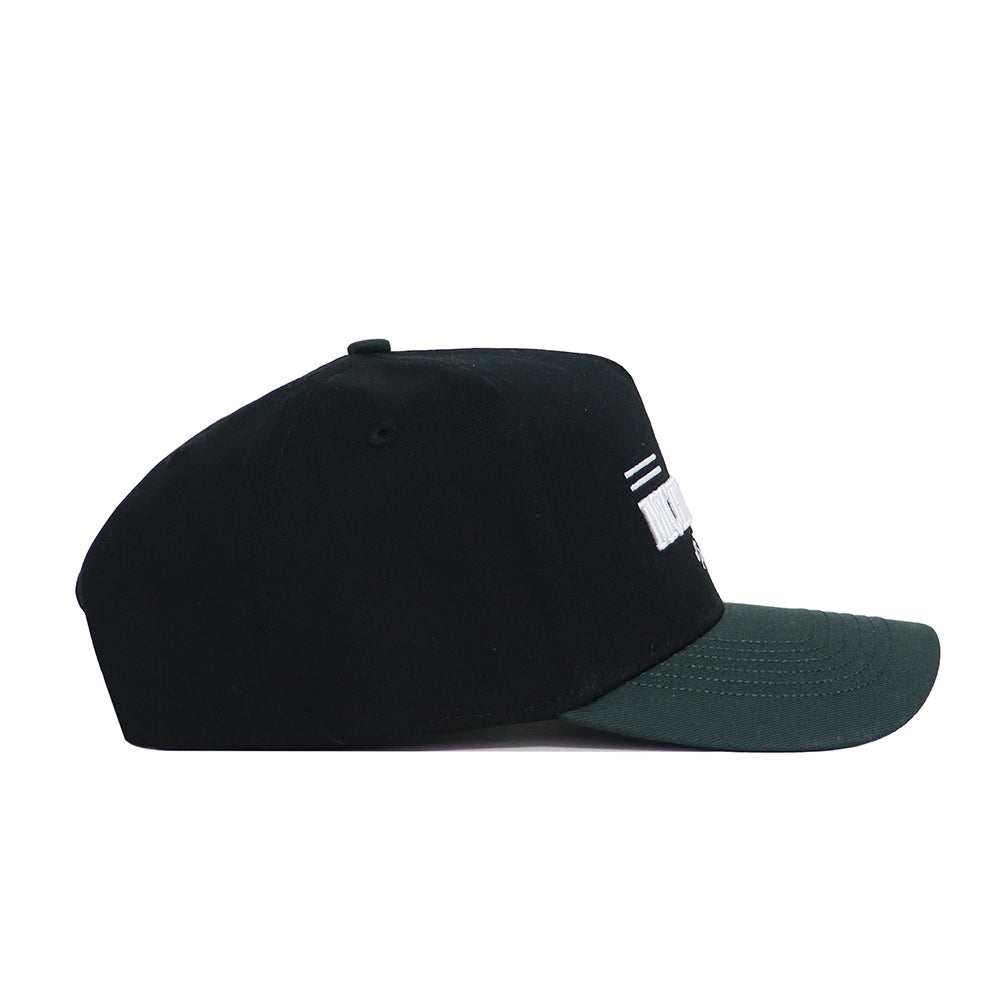 The No Rivals Michigan State Tailgate Hat is a black snapback with a dark green brim, shown side-on against a white background. It features partial white embroidered text, two white lines on the front, and is made from high-quality cotton.