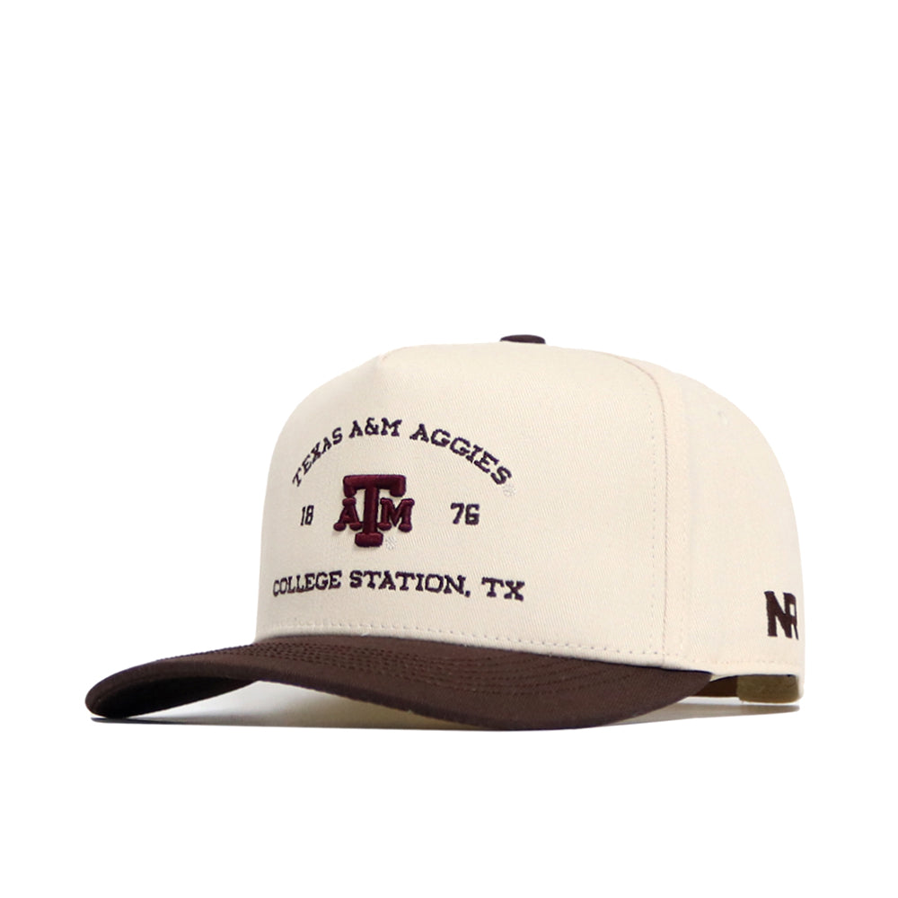 The No Rivals Texas A&M Outlaw Hat - Classic is a white and brown structured snapback featuring "Texas A&M Aggies 1876 College Station, TX" and the logo on the front, with "NR" on the side. Made from premium cotton for lasting comfort.