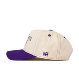 The Minnesota State Mankato Vintage Hat by No Rivals is a cream-colored snapback featuring a purple brim, purple top button, purple stitched eyelets, and the NR logo embroidered in purple on the side above the brim.