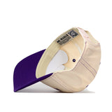 The Minnesota State Mankato Vintage Hat by No Rivals is shown from below, highlighting the inside label, sweatband, and adjustable strap. This officially licensed snap back cap features a purple visor, while the rest of the hat is cream-colored.
